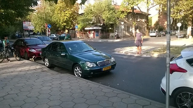 Автомобил върху „зебра”, шофьорът пие кафе и гледа пешеходците 